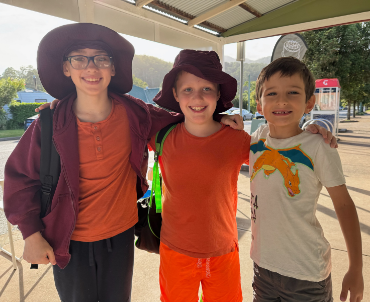 Three boys dressed in orange for Harmony Day