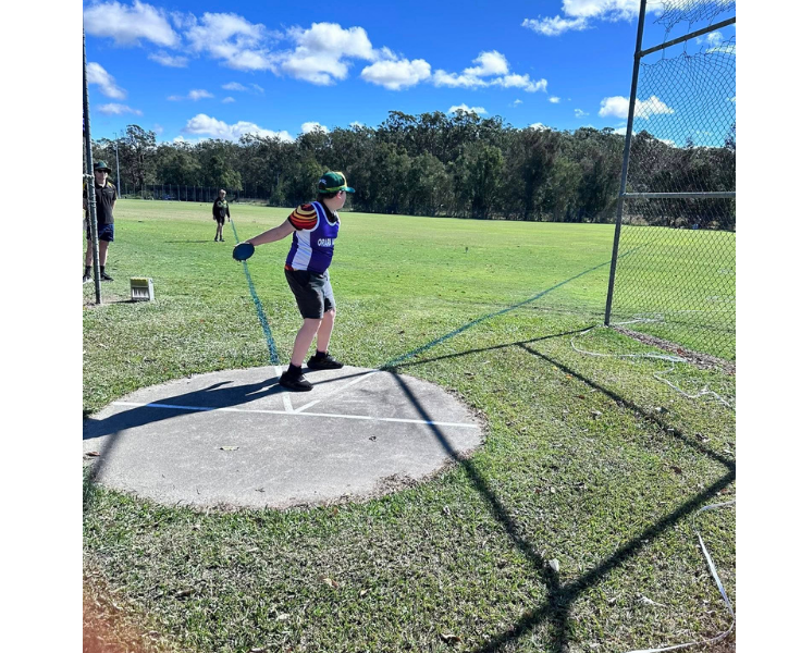 A year 6 male student representing the Orara Valley throwing a discus at the Coffs Harbour & District Athletics Carnival.
