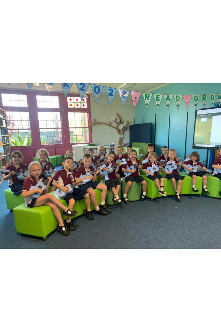 A group of students sitting in the library all with blue ukulele's