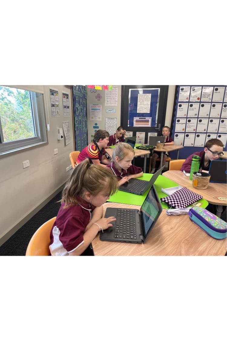 A small group of students at their desks with computers