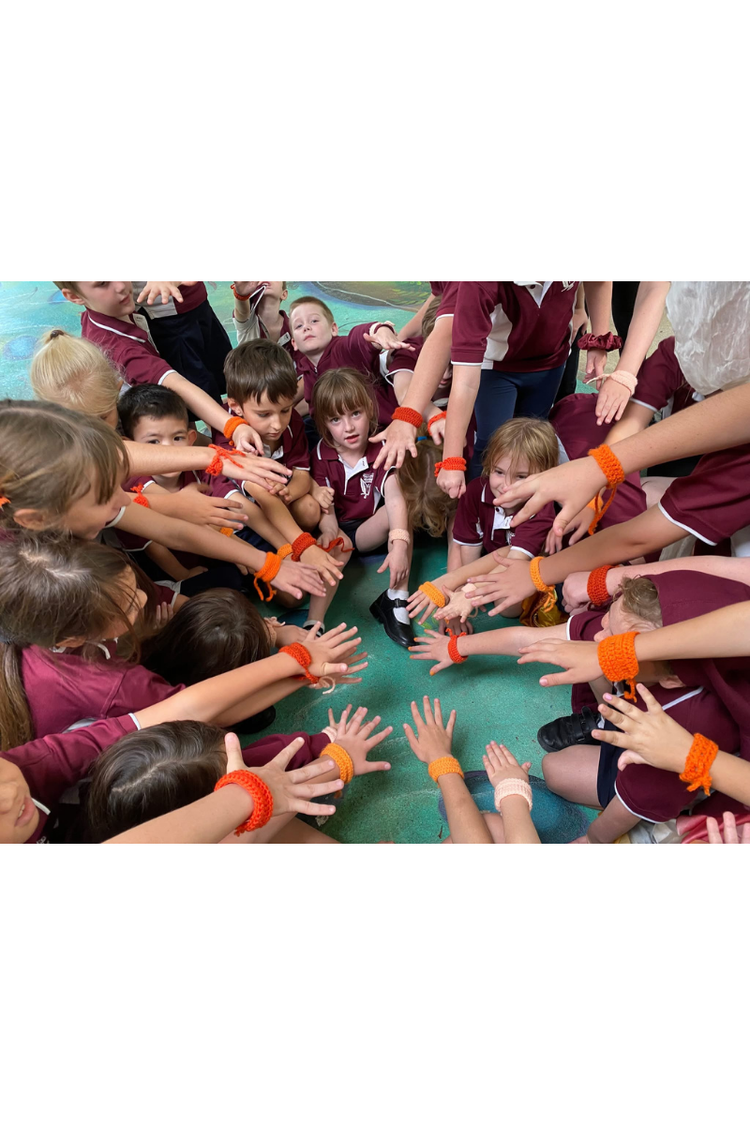 multiiple students in a circle with hands all together in the middle