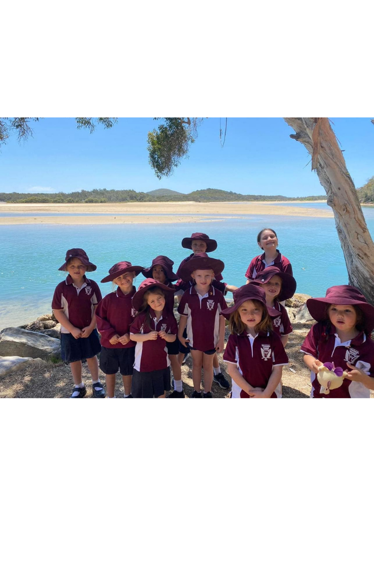 A small group of students in uniform with Moonee Creek in the background